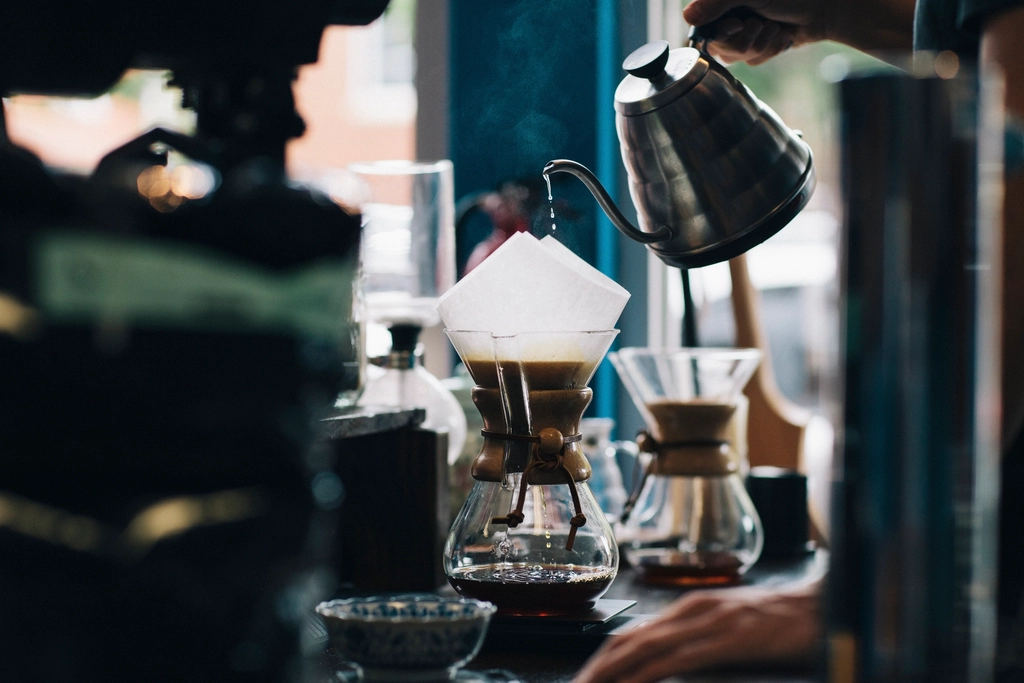 person pouring water jug coffee